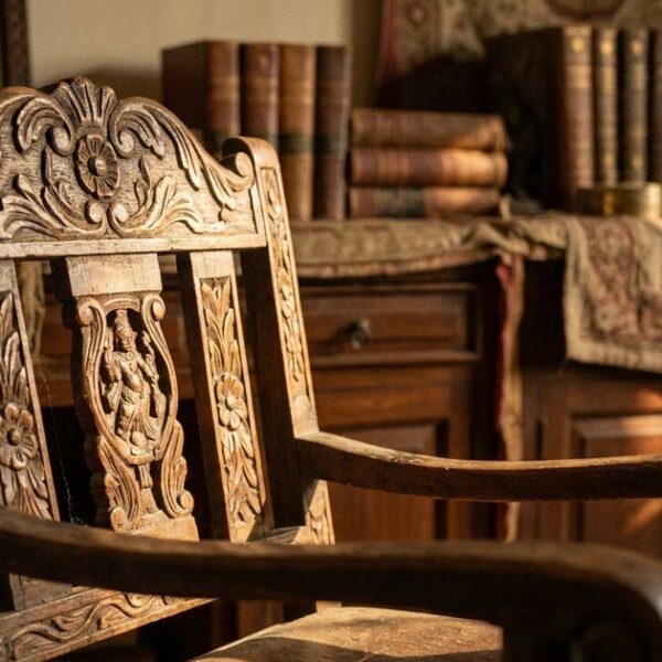 Close-up of an ornate empty wooden chair, symbolizing investment restraint, in warm light and an Indian setting.