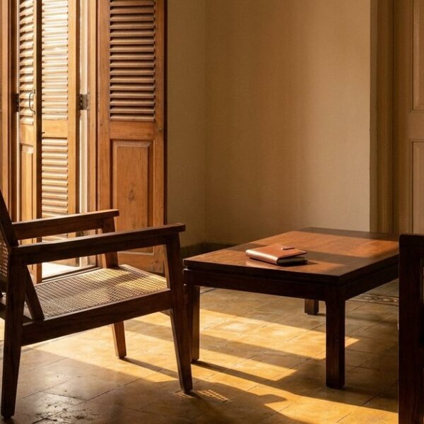 An Indian living room with sunlight filtering in, focusing on a closed checkbook to illustrate investment caution in angel investing.