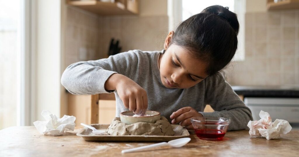 Indian girl absorbed in a science experiment for an article about AI and children's curiosity in learning.