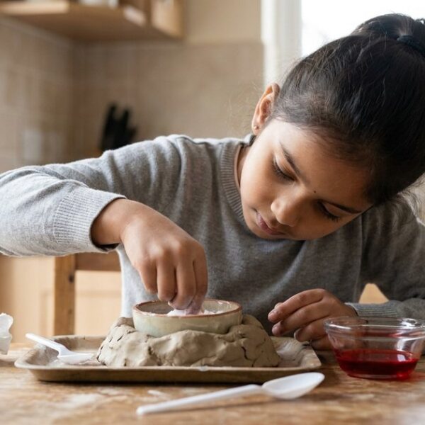 Indian girl absorbed in a science experiment for an article about AI and children's curiosity in learning.