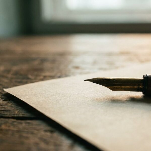 Close-up of an Indian ink pen and parchment symbolizes NLP's impact on communication for Indian business leaders.