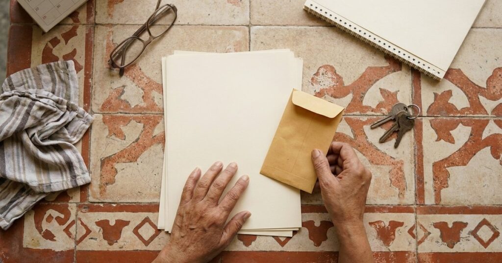 Older Indian investor arranging long-term papers and an emergency cash envelope for patient financial planning