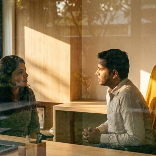 Business partners discuss goal setting in an office, highlighting NLP well-formed outcomes with warm daylight and decor.
