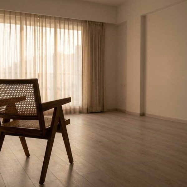 A quiet Indian living room with a solitary chair under soft morning light, symbolizing the art of closing sales.