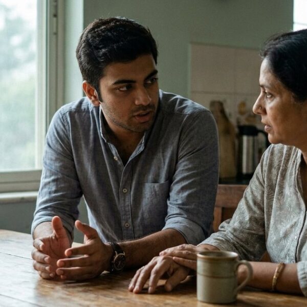 An Indian professional discusses balancing family with entrepreneurial goals at a kitchen table in soft light.