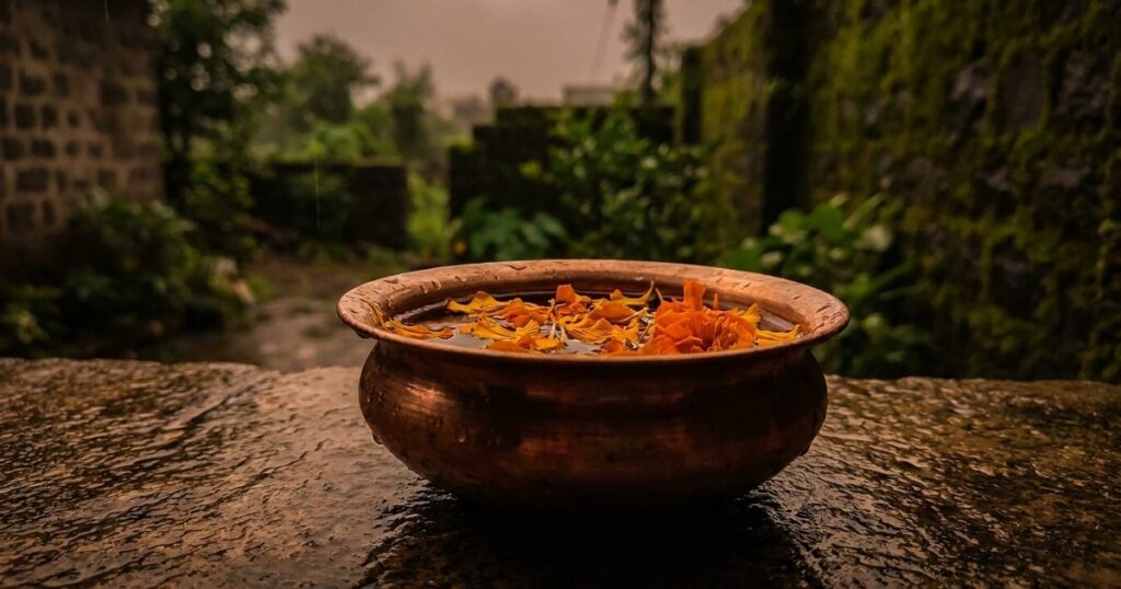 Close-up of a kalash with marigold petals on a stone surface, symbolizing the approach to job search in India.
