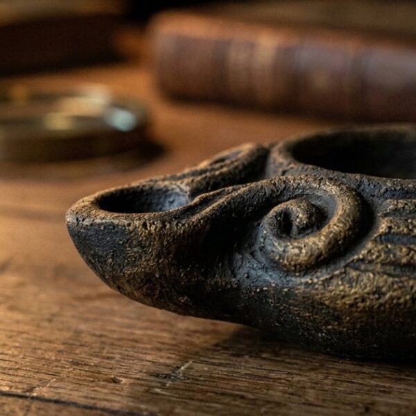 Handcrafted clay lamp on a desk symbolizes lifelong learning's balance of tradition and modernity in education.