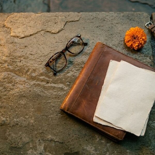 An overhead view shows a thoughtful arrangement symbolizing alternative job search methods, including a marigold flower and closed folder.