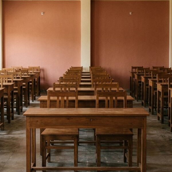 Empty Indian classroom with rows of identical desks highlights standardization in education systems.
